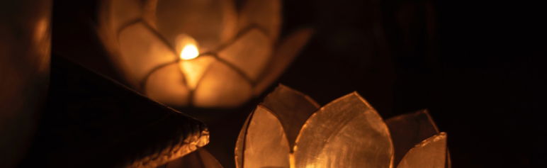 close up image of two candle flames in lotus flower candle holders